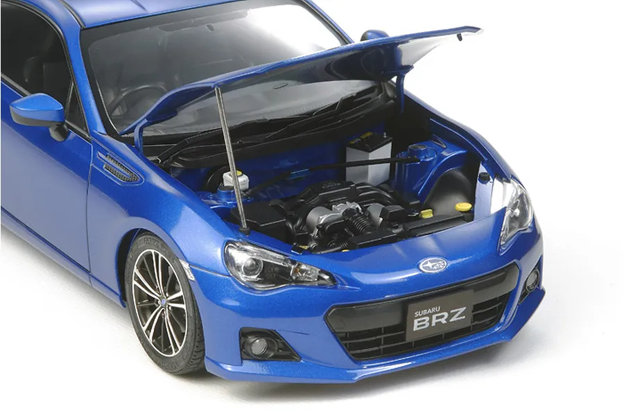 A high-detail 1/24 scale model of a blue Subaru BRZ with its hood open, revealing the engine bay, set against a plain white background.