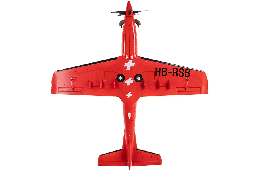 Top-down studio view of the E-Flite Pilatus PC-21 RC plane in red livery with Swiss cross markings and HB-RSB registration on the wing.