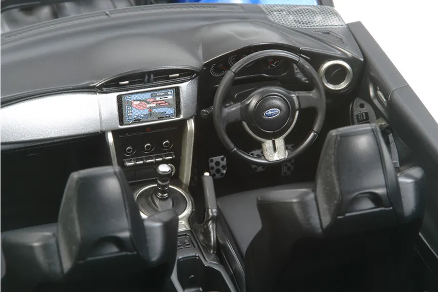 Detailed interior view of a Tamiya 1/24 scale Subaru BRZ plastic model kit showing the dashboard, steering wheel, and front seats.