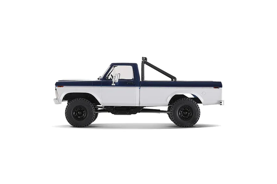 Side view profile of the FMS FCX18 II Ford F-100 RC rock crawler in blue and white on a white background.