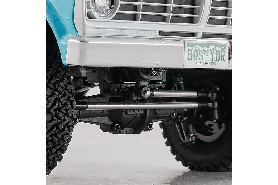 Close-up of the front suspension, axle, and steering linkage on the FMS FCX18 Ford F-100 RC rock crawler.