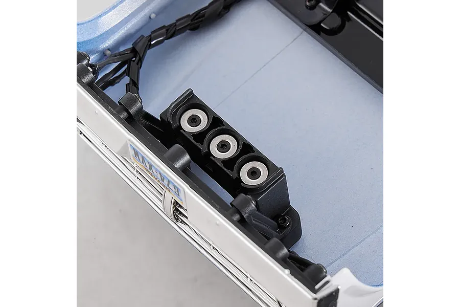 Close-up interior view of the FMS FCX18 II Ford F-100 RC crawler blue body shell showing front mounting detail and wiring.
