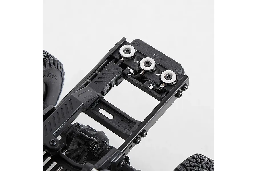 Close-up studio view of the black plastic chassis frame and electronics mounting plate of a 1/18 scale RC model car.