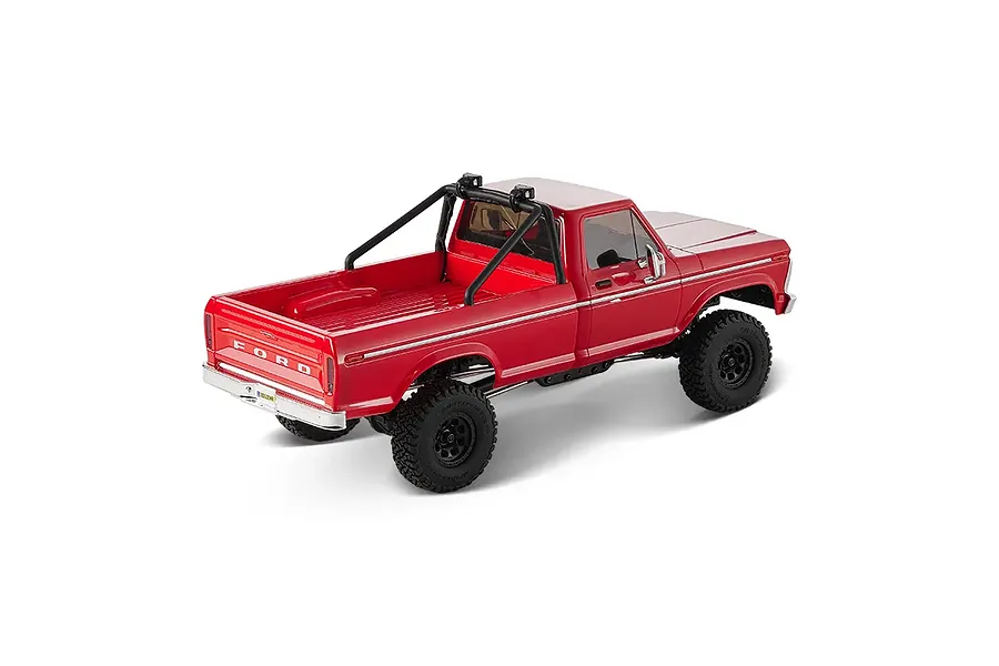 Rear-three-quarter studio shot of the FMS FCX18 II Ford F-100 RC rock crawler in red, showing the truck bed and roll bar.