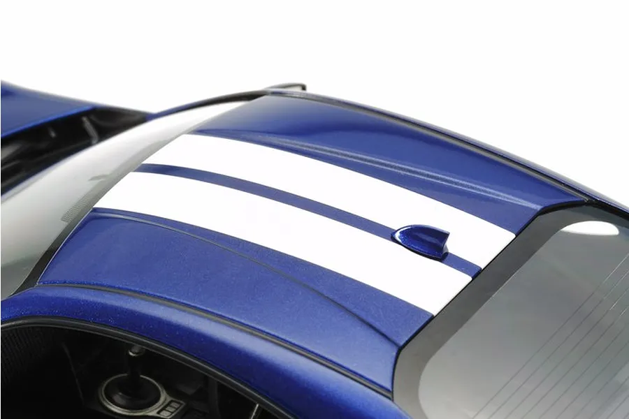 Close-up of the roof of a blue Tamiya 1/24 scale Subaru BRZ model car featuring dual white racing stripes and a shark fin antenna.