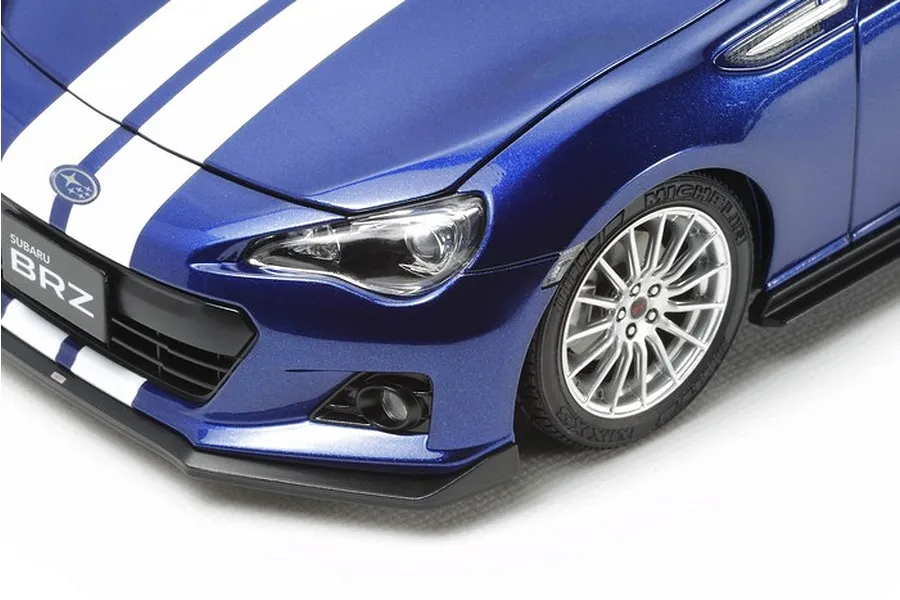 Close-up of a blue Tamiya 1/24 scale Subaru BRZ model car with white racing stripes on a white background.