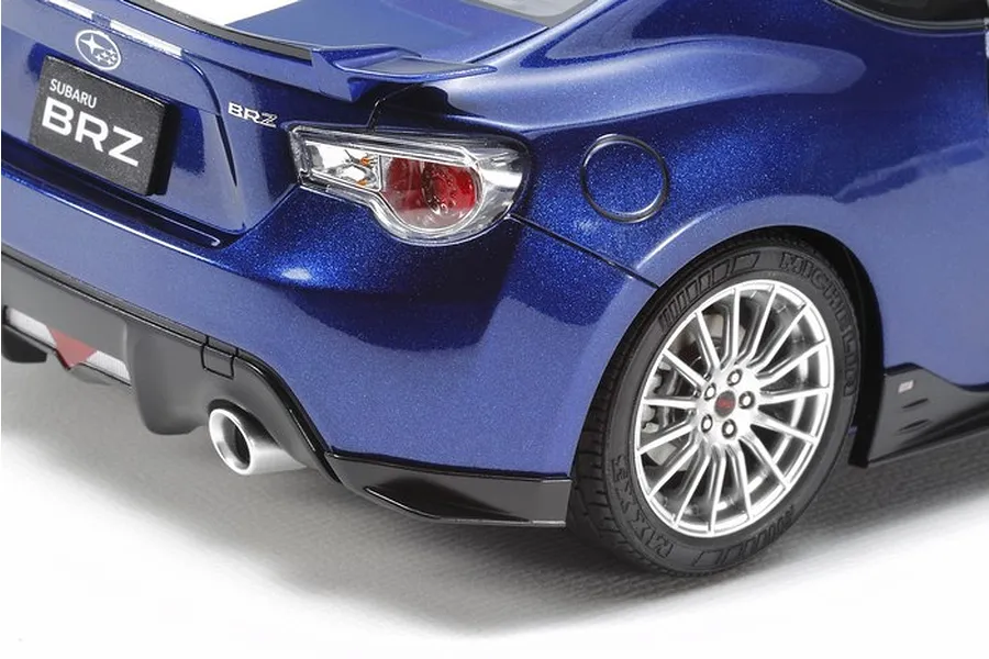 Close-up of the rear quarter of a blue Tamiya 1/24 scale Subaru BRZ model car, showing the taillight, wheel, and exhaust detail.