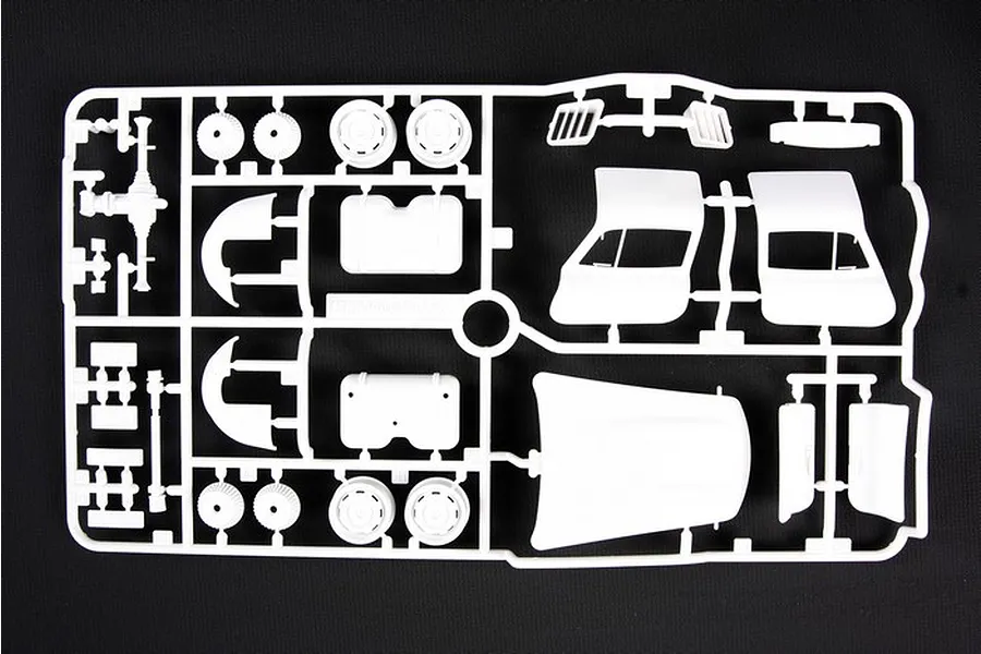 A white plastic sprue containing various unpainted model car parts for a Tamiya 1/24 scale Mercedes-Benz 300SL model kit, viewed from above.