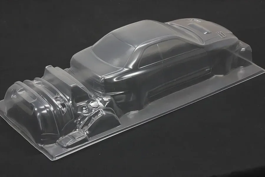 Unpainted clear polycarbonate RC car body shell of a Subaru Impreza 22B STi on a dark background.