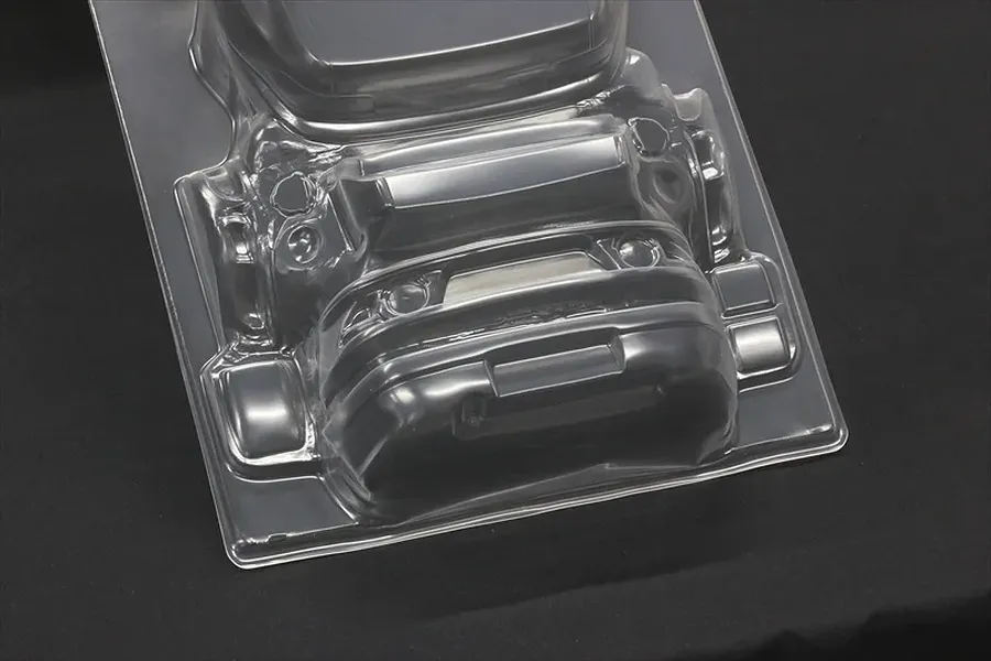 Unpainted clear polycarbonate RC car body accessory parts on a dark background.