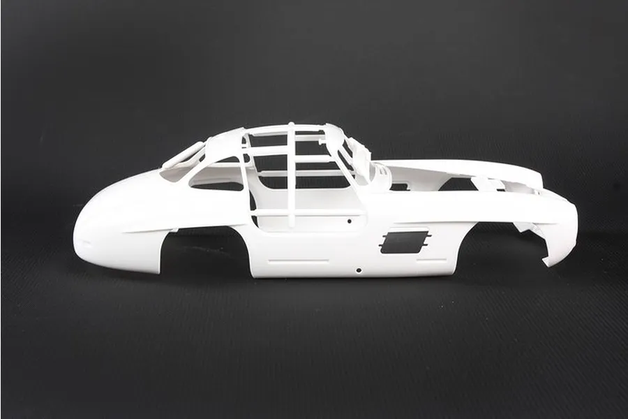 Side view of an unpainted white plastic model car body for a Mercedes-Benz 300SL, shown against a dark background.