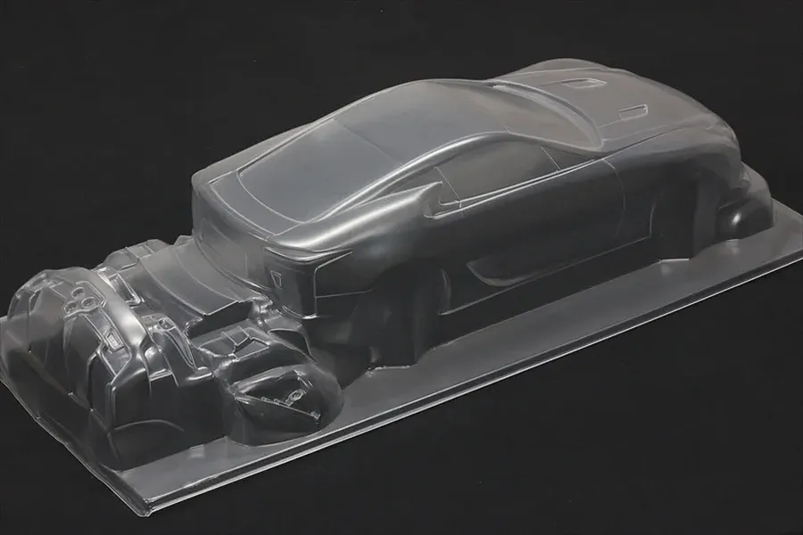 Clear unpainted RC car body shell showing sleek coupe styling on a black background.
