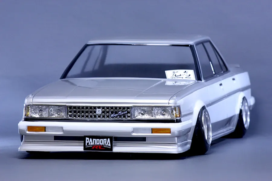 Front three-quarter studio view of a painted Toyota Cresta GX71 RC drift car body shell mounted on a chassis with custom wheels.