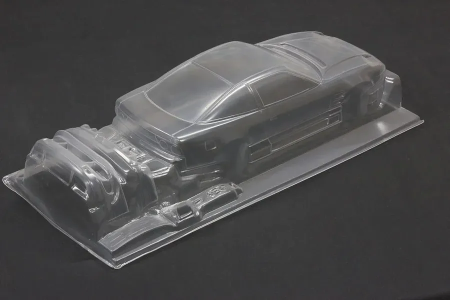 Clear unpainted 1/10 scale RC car body shell showing the rear and side profile on a dark background.