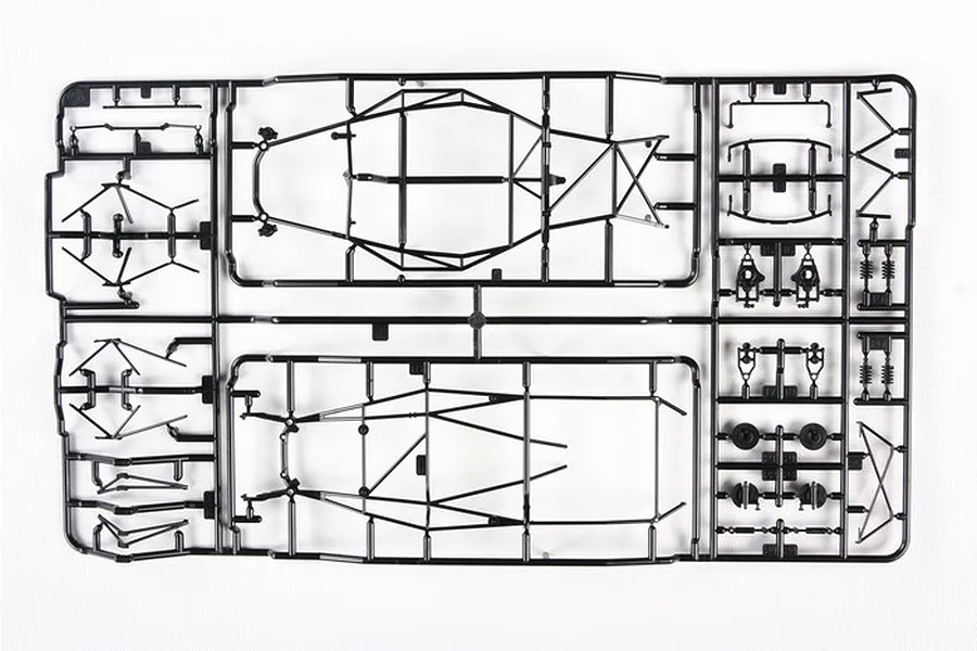 A black plastic sprue containing various model car chassis and suspension parts for a Tamiya 1/24 scale model kit.