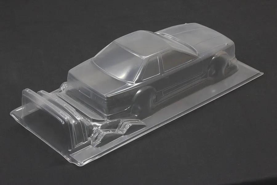 Unpainted clear polycarbonate 1/10 scale RC car body shell on a dark surface