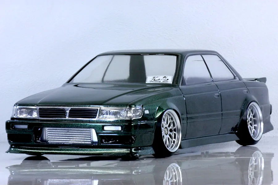 Dark green metallic RC drift car body shell mounted on a chassis with custom wheels and intercooler visible.