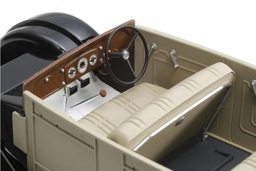 Interior view of a 1/24 scale Tamiya Toyota Model AA model car showing the dashboard, steering wheel, and bench seat.