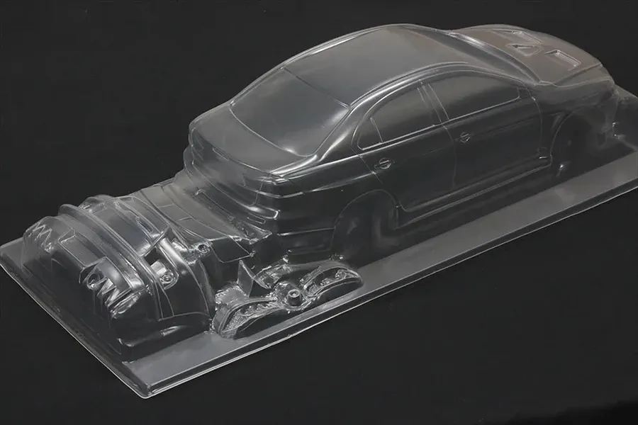 Clear unpainted RC car body shell molded in transparent plastic on a black background