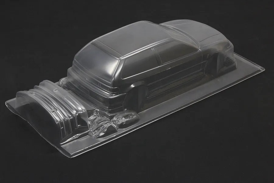 Unpainted clear polycarbonate 1/10 scale Honda Civic EF9 RC body shell on a dark background.