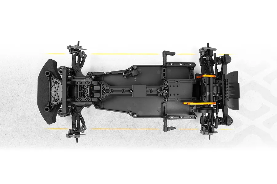 Top-down studio view of an assembled RC car chassis showing black plastic construction, suspension arms, and orange anodized accents against a white background.