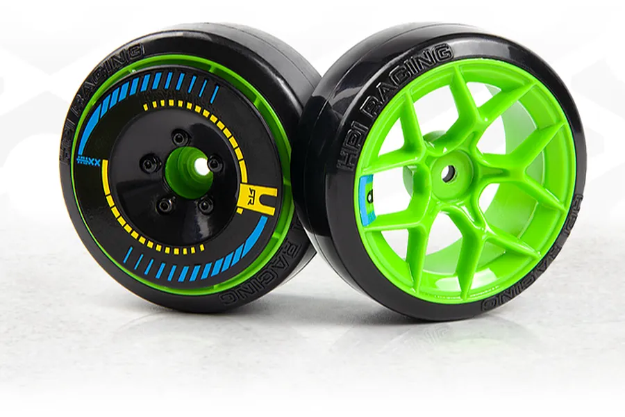 Two 1/10 scale RC drift car wheels with green rims, black slick tyres, and printed spoke details on a white surface.