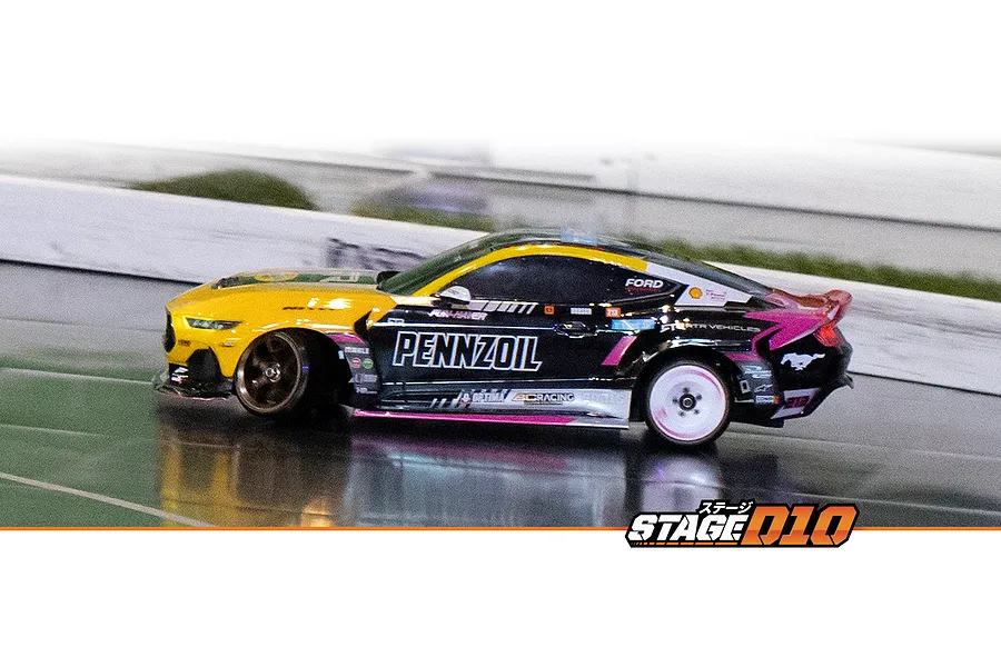 HPI Stage-D10 Ford Mustang GT RC drift car in action on an indoor track, featuring a yellow and black Pennzoil livery.
