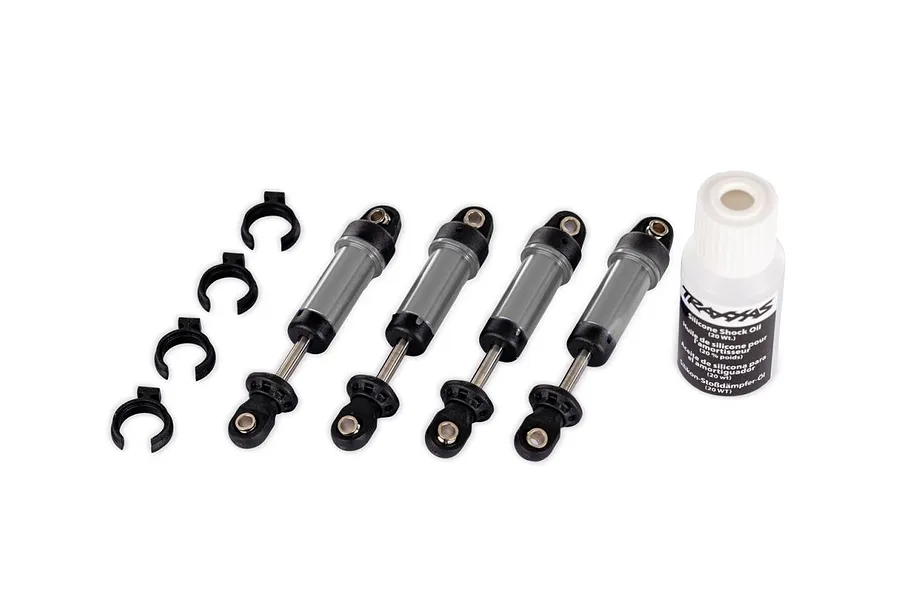 Set of four grey aluminium GTM shock absorbers with springs clips and shock oil against a white background.