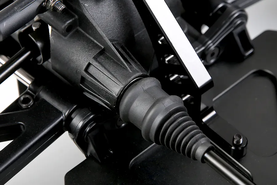 Close-up view of the RC buggy drive shaft boot and differential housing, showing durable plastic and metal construction.