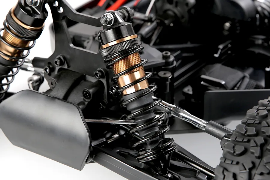 Close-up of the front suspension and shock absorber assembly on the Rovan Voyager 5 V2 1/5 scale RC buggy.
