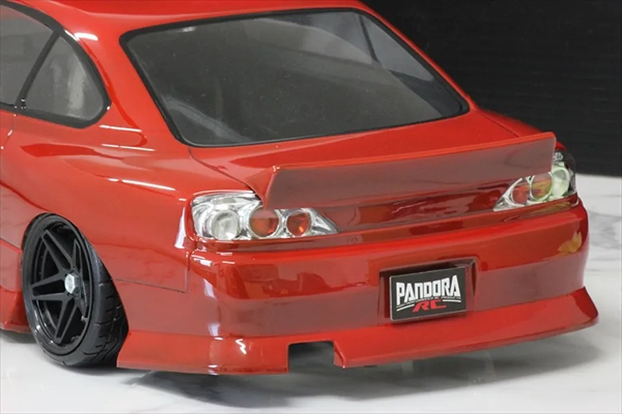 Rear view of a red RC drift car body installed with a ducktail spoiler mounted on the trunk lid.