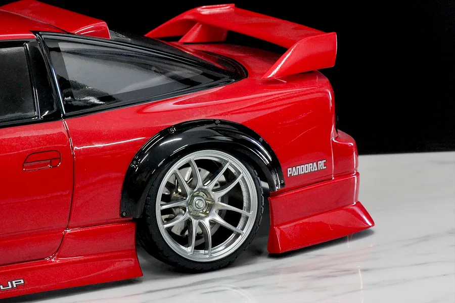Close-up of a red RC car body featuring a black over fender set installed over the rear wheel, showcasing Pandora RC branding.