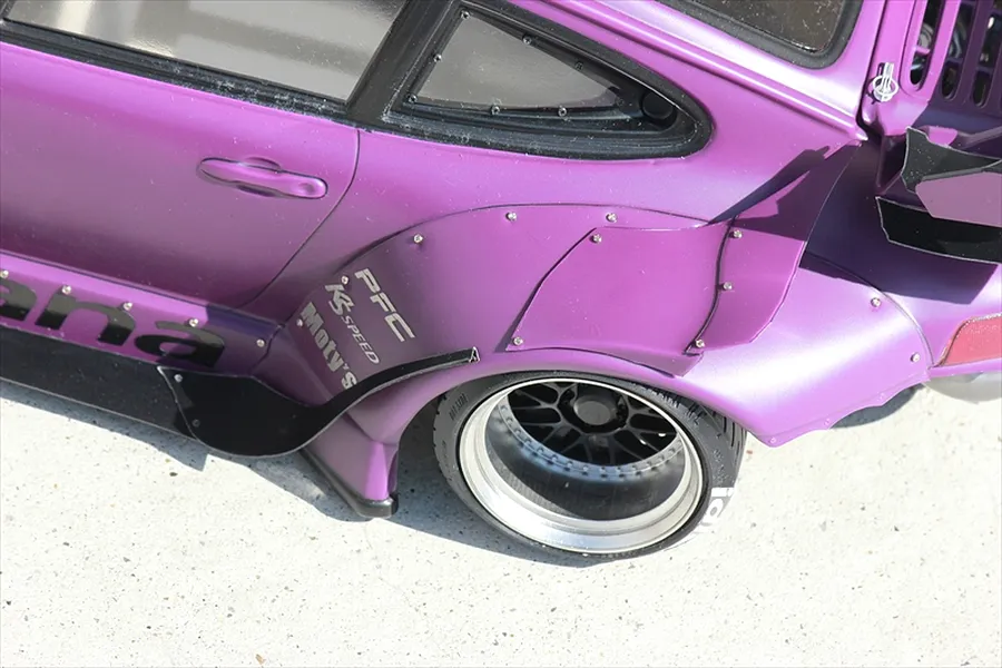 Close-up of a purple RC drift car body showing the rear wide fender set mounted over a deep dish wheel.