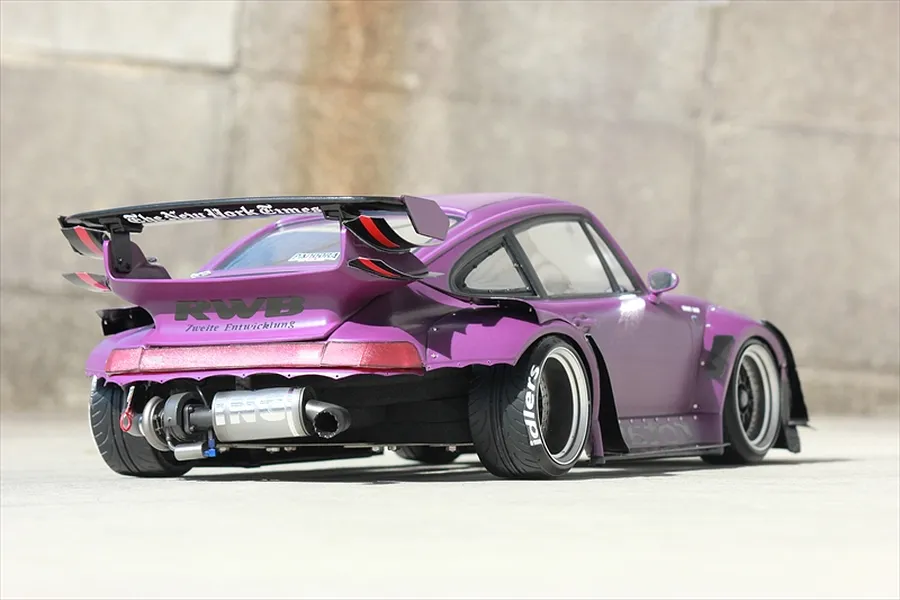 Rear-three-quarter view of a purple Pandora RC Porsche body shell featuring wide fenders, a large rear wing, and custom exhaust details.