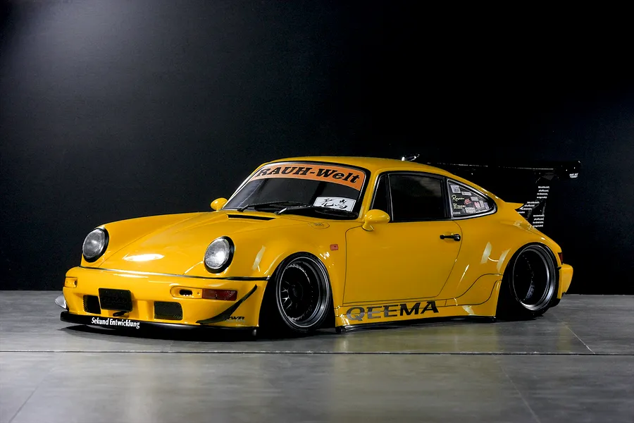 Yellow Pandora RC RWB 993 Type drift car body shell with wide body kit, large rear wing, and decals displayed in a studio setting.