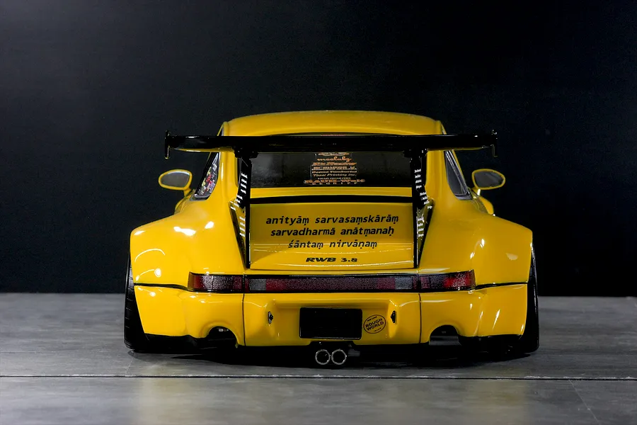 Rear view of a yellow Pandora RC RWB 993 style body shell with wide fenders, large rear wing, and detailed decals.