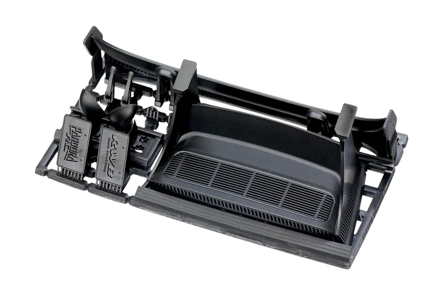 Black plastic RC car body accessory parts tree including a rear wing and interior details on a white background.