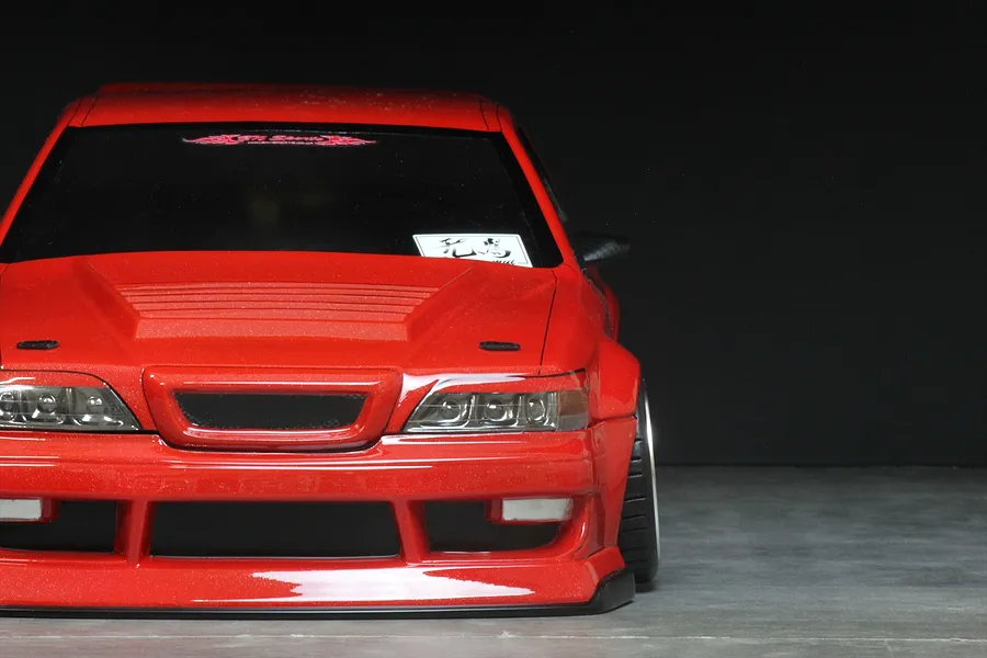 Front view of a red RC drift car body shell with a custom vented hood and BN-Sports styling against a dark background.