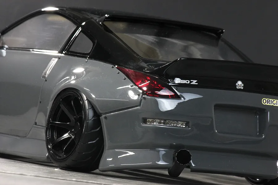 Rear-quarter close-up of a grey Pandora RC 350Z Fairlady body shell featuring black roof, wide fenders, and exhaust detail.