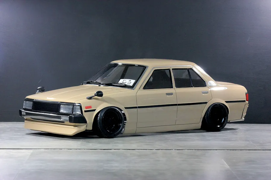 Pandora RC Toyota Corolla KE70 RC drift car body shell painted beige with black wheels on a studio floor.