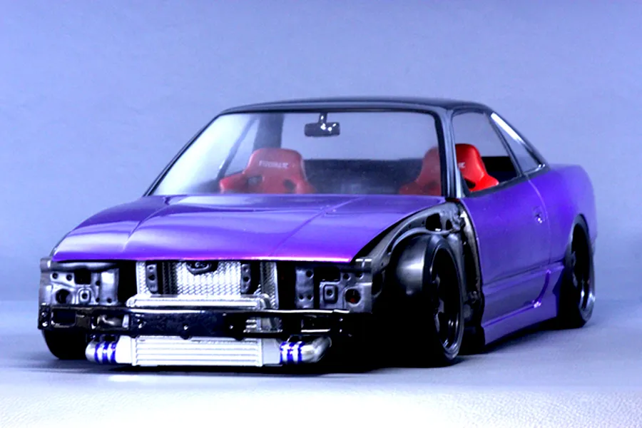Front three-quarter view of a purple RC drift car body installed with a detailed interior set, intercooler, and front-end detailing.