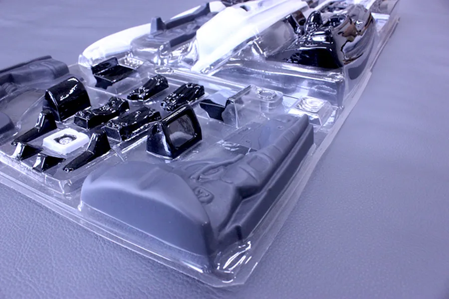 Unopened clear blister pack containing molded plastic interior accessory parts for an RC model car.