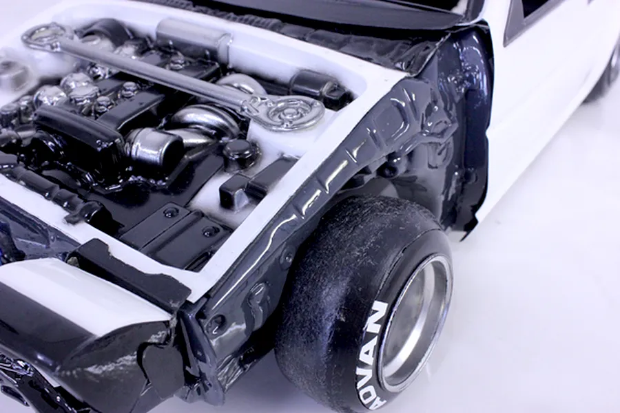 Close-up view of an RC car detailed engine bay and inner fender set installed in a white model body.