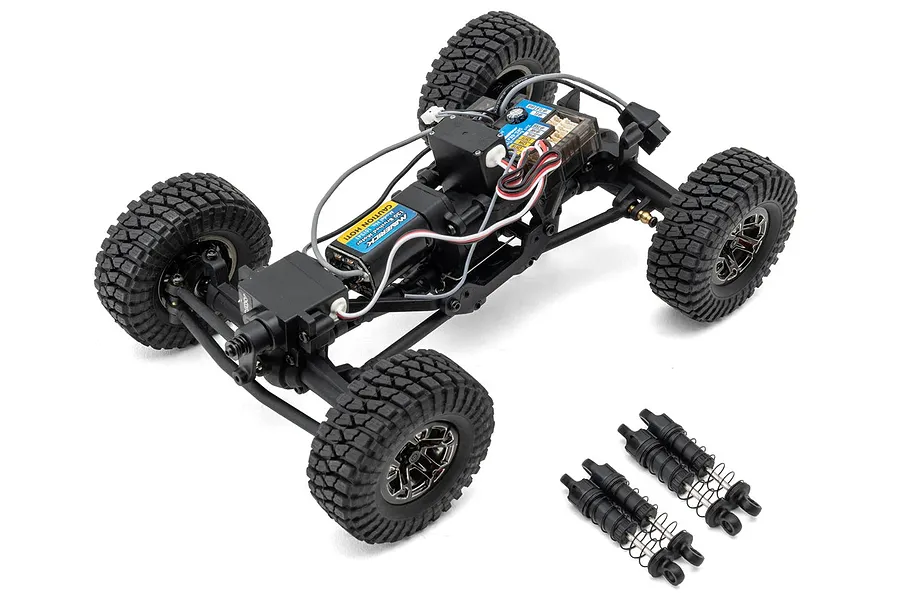High angle studio view of the Maverick Scout-24 RC rock crawler chassis without body shell, showing electronics and separate shock absorbers.