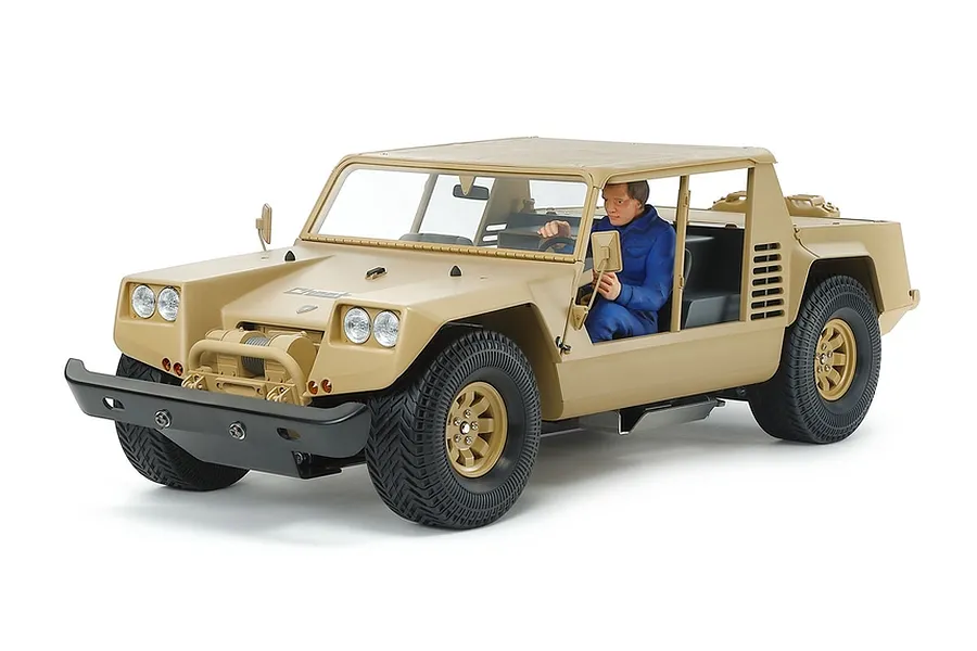 Tamiya XR311 combat support vehicle RC car in desert tan with a driver figure, shot against a white background.
