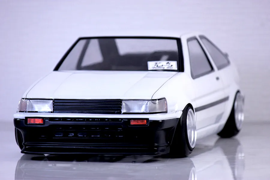 Front three-quarter view of a white Pandora RC Toyota AE86 Corolla Levin 2DR model car on a reflective surface.