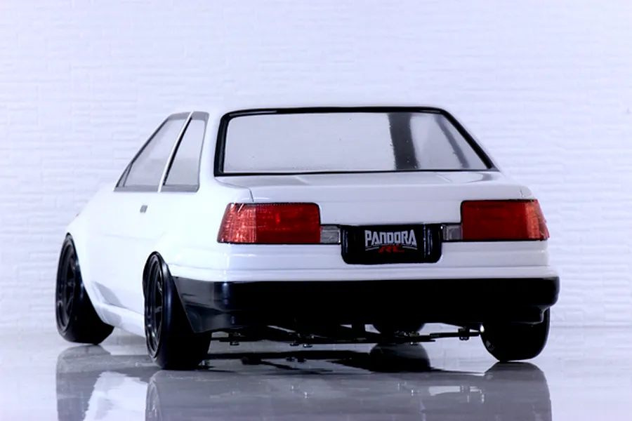 Rear view of a white Pandora RC Toyota AE86 Corolla Levin 2-door RC car body on a reflective white surface.