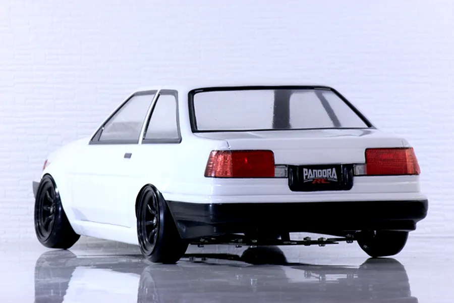 Rear three-quarter view of a white Pandora RC Toyota AE86 Corolla Levin 2-door RC car body with black wheels and bumper.