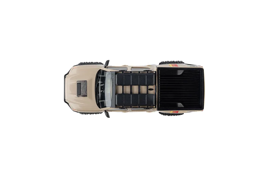 Top down view of the brown Axial Toyota Tacoma RC rock crawler truck on a white background, showcasing its roof rack and truck bed.