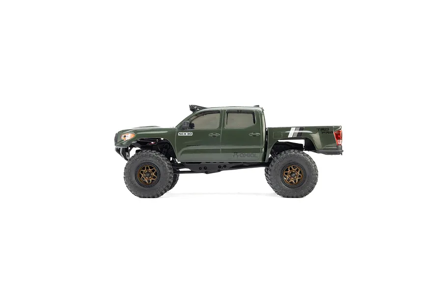Studio side profile shot of the green Axial SCX30 Toyota Tacoma RC rock crawler truck.